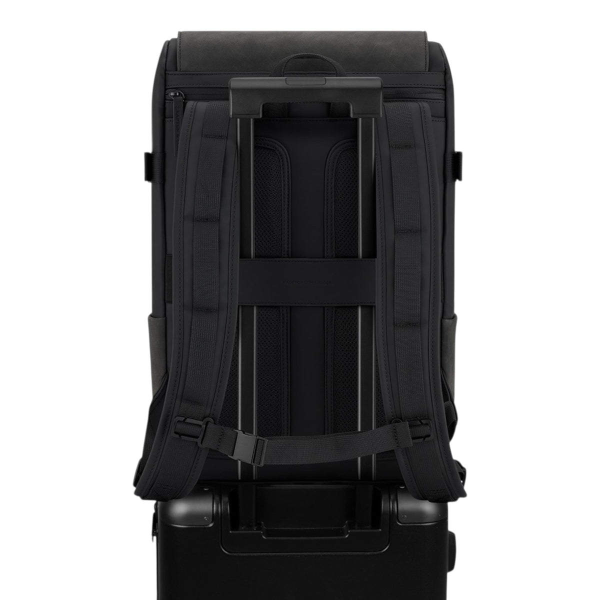 Lieblingstasche Bali Pro black backpack with padded straps and trolley sleeve, attached to a black suitcase.