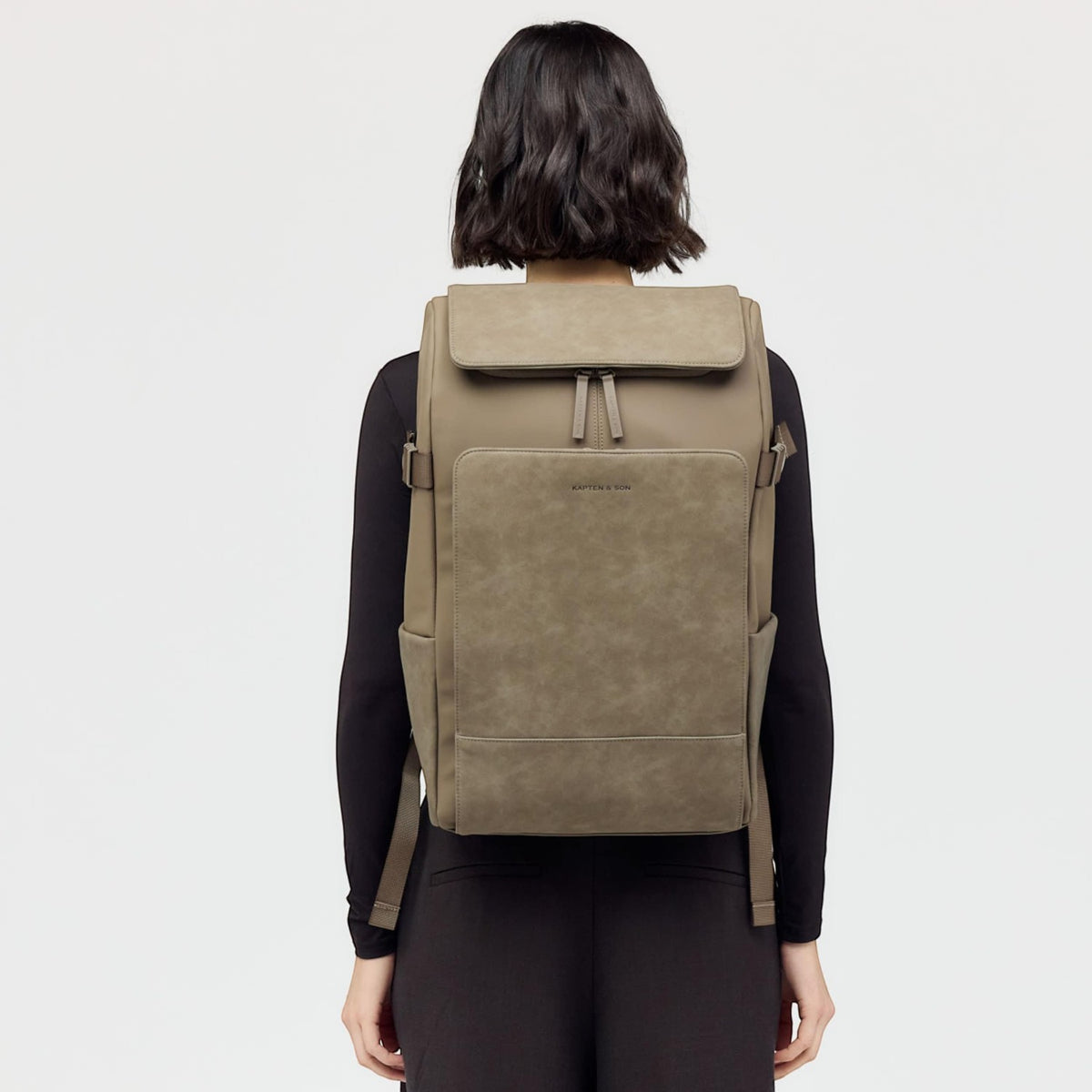Lieblingstasche Bali Pro taupe faux leather backpack with flap closure and front pocket, worn by a model.