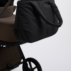Lieblingstasche Cloud Horizon black padded tote bag hanging from a brown stroller handle