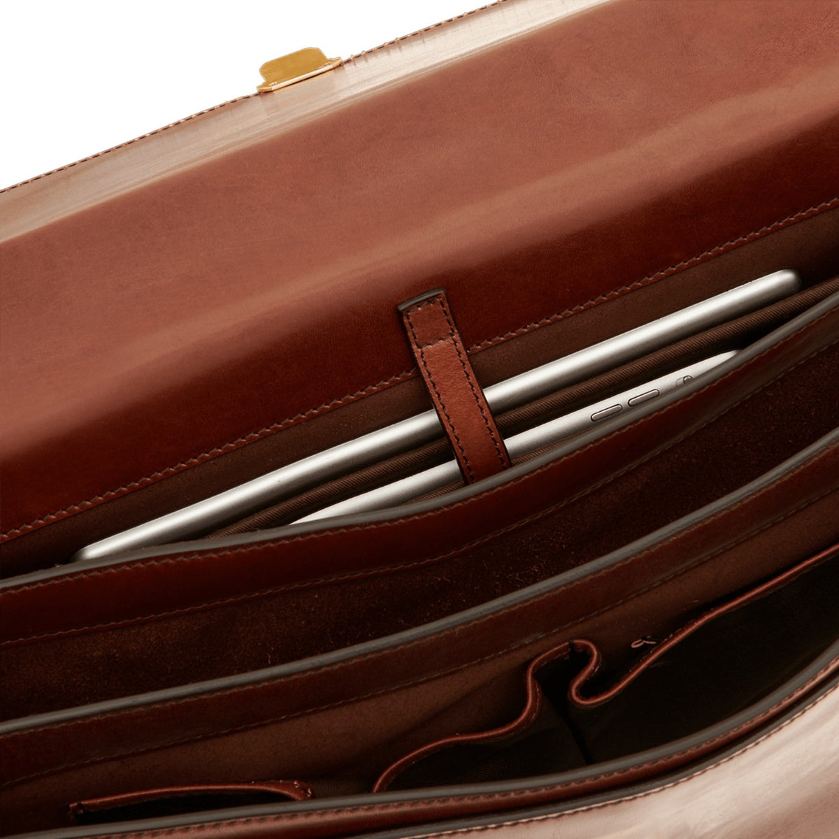 Lieblingstasche brown leather briefcase interior with a tablet secured by a leather strap.