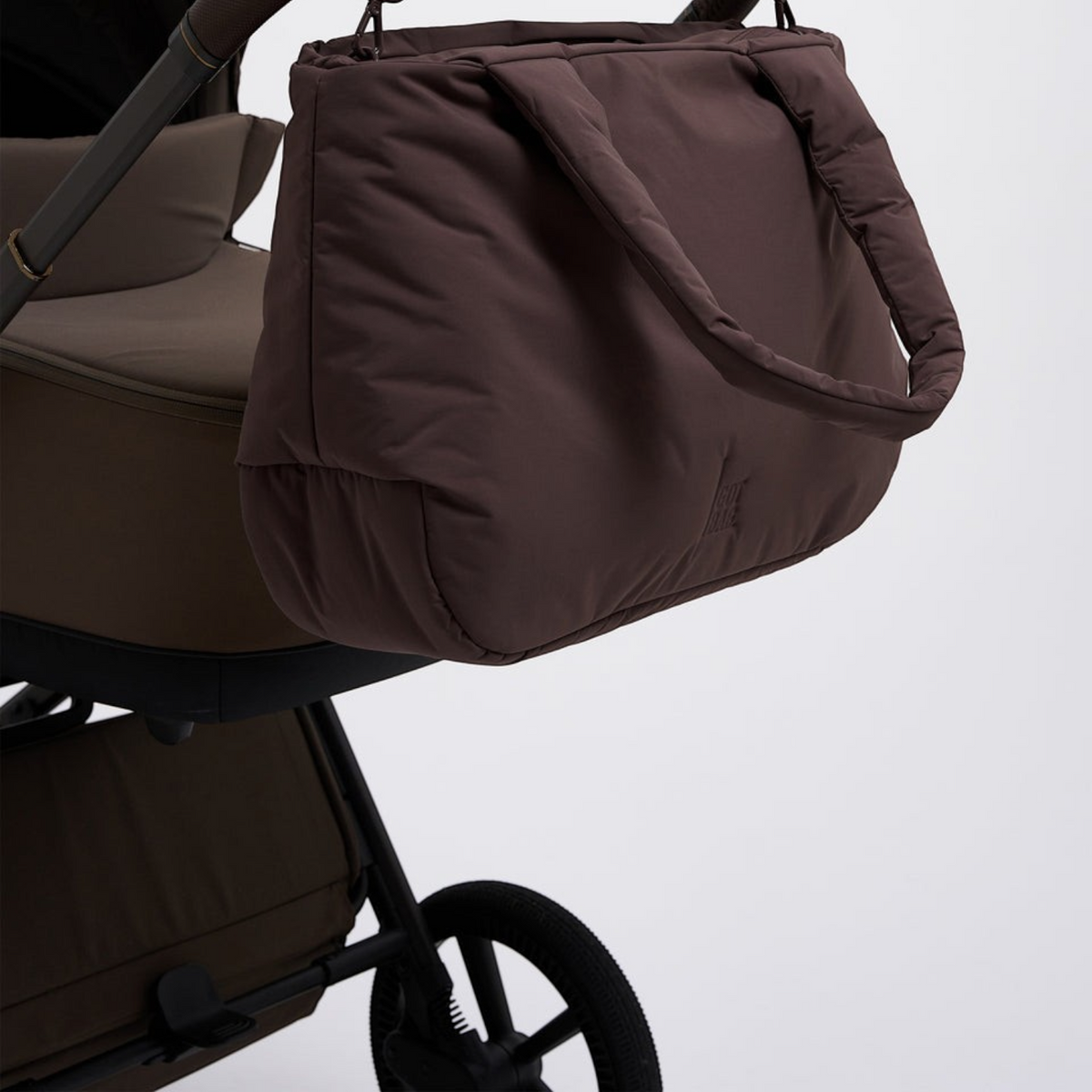 Lieblingstasche Cloud Horizon brown padded tote bag hanging from a stroller handle