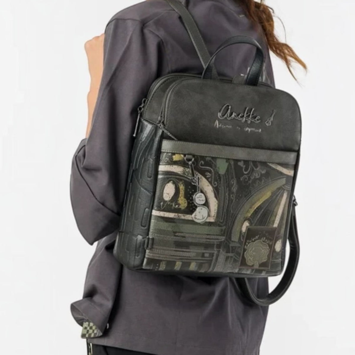 Woman wearing a Lieblingstasche dark grey patterned backpack with artistic graphic details on the front pocket