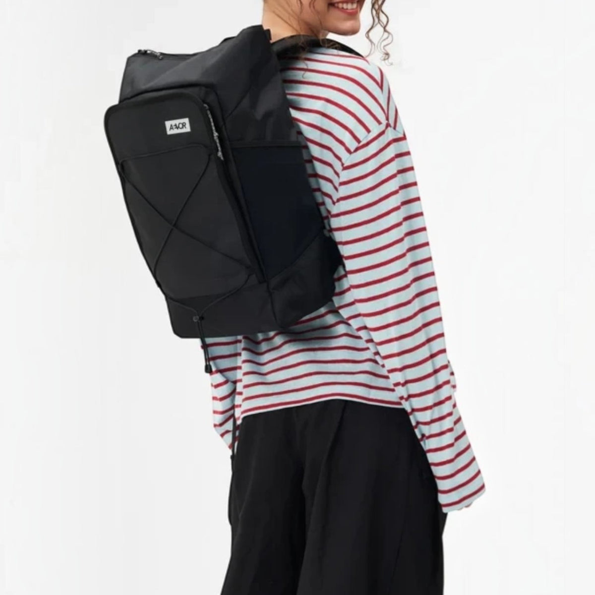 Lieblingstasche Day Pack FLX black backpack worn by a smiling woman in a striped long-sleeve shirt