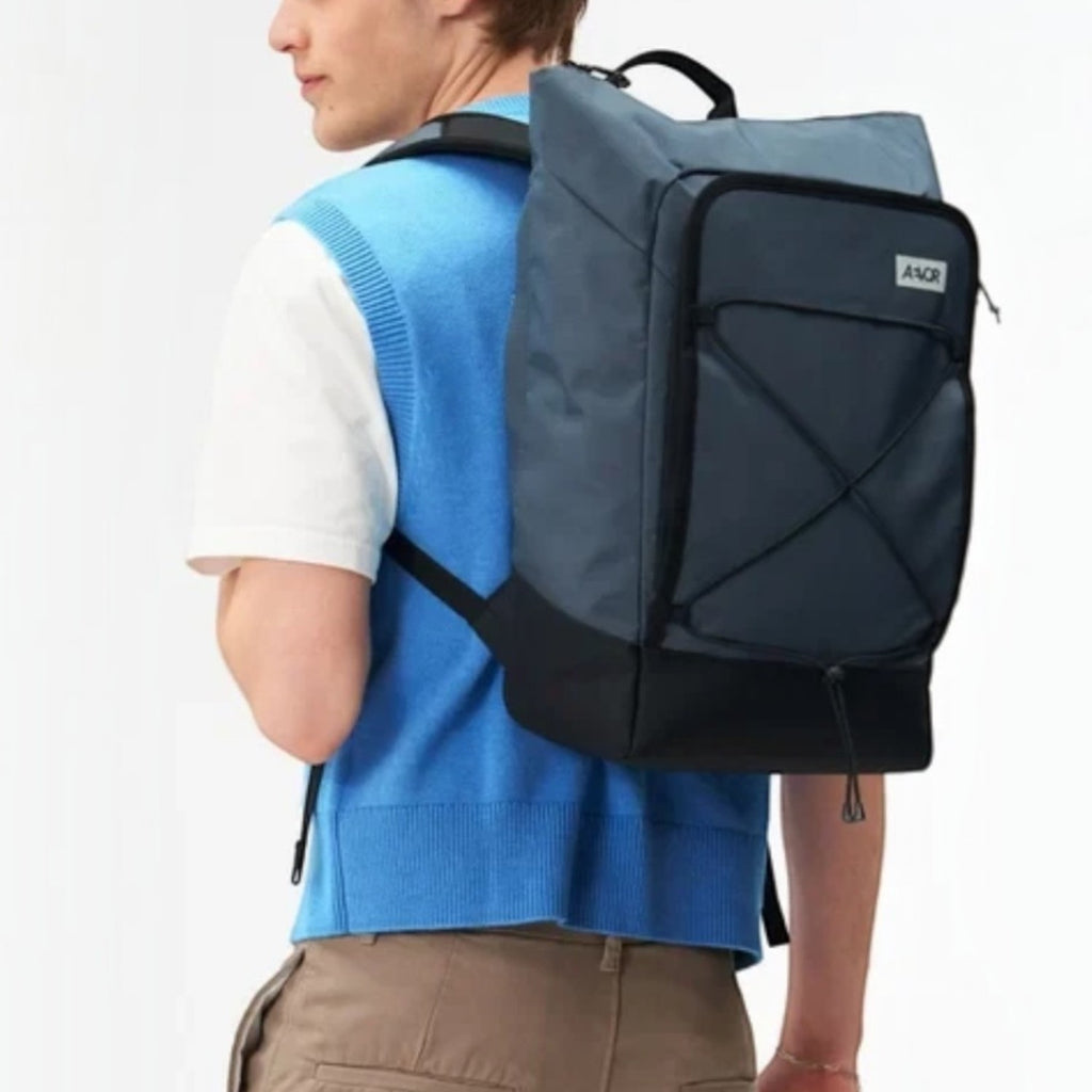 Lieblingstasche Day Pack FLX blue and black ergonomic backpack worn by a man against a white background
