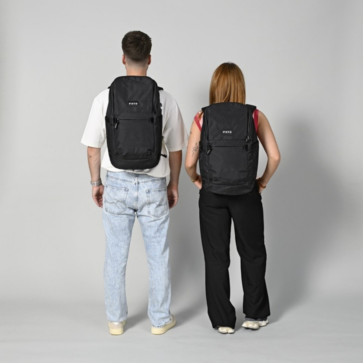 Lieblingstasche eoto Easy27 black recycled daypack worn by a man and a woman, showing back view and fit.