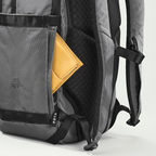Lieblingstasche eoto Small16 grey daypack with a yellow wallet in the side pocket, showing durable recycled fabric.