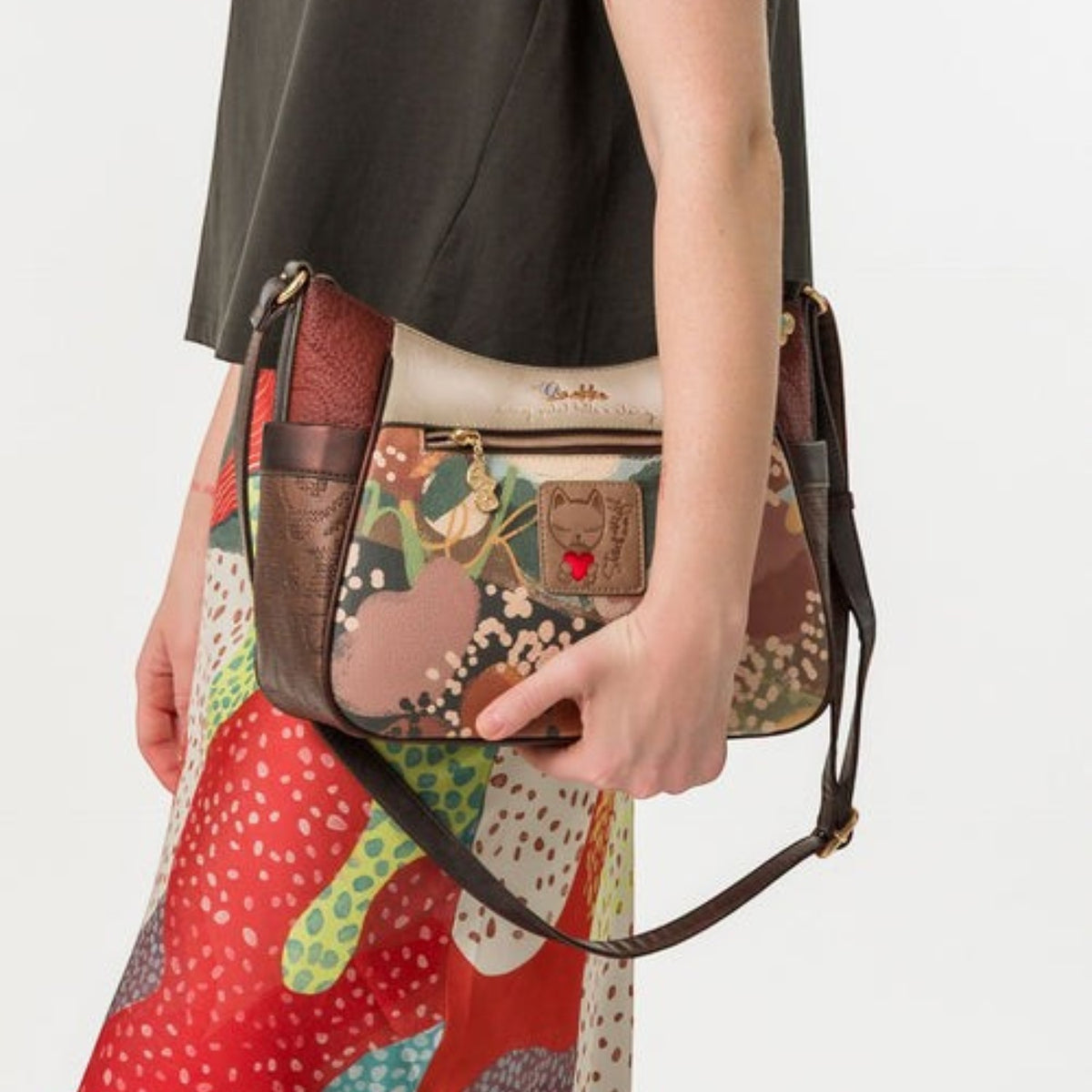 Lieblingstasche cross-body bag with a multi-colored floral pattern, brown leather trim, and a cat charm detail.