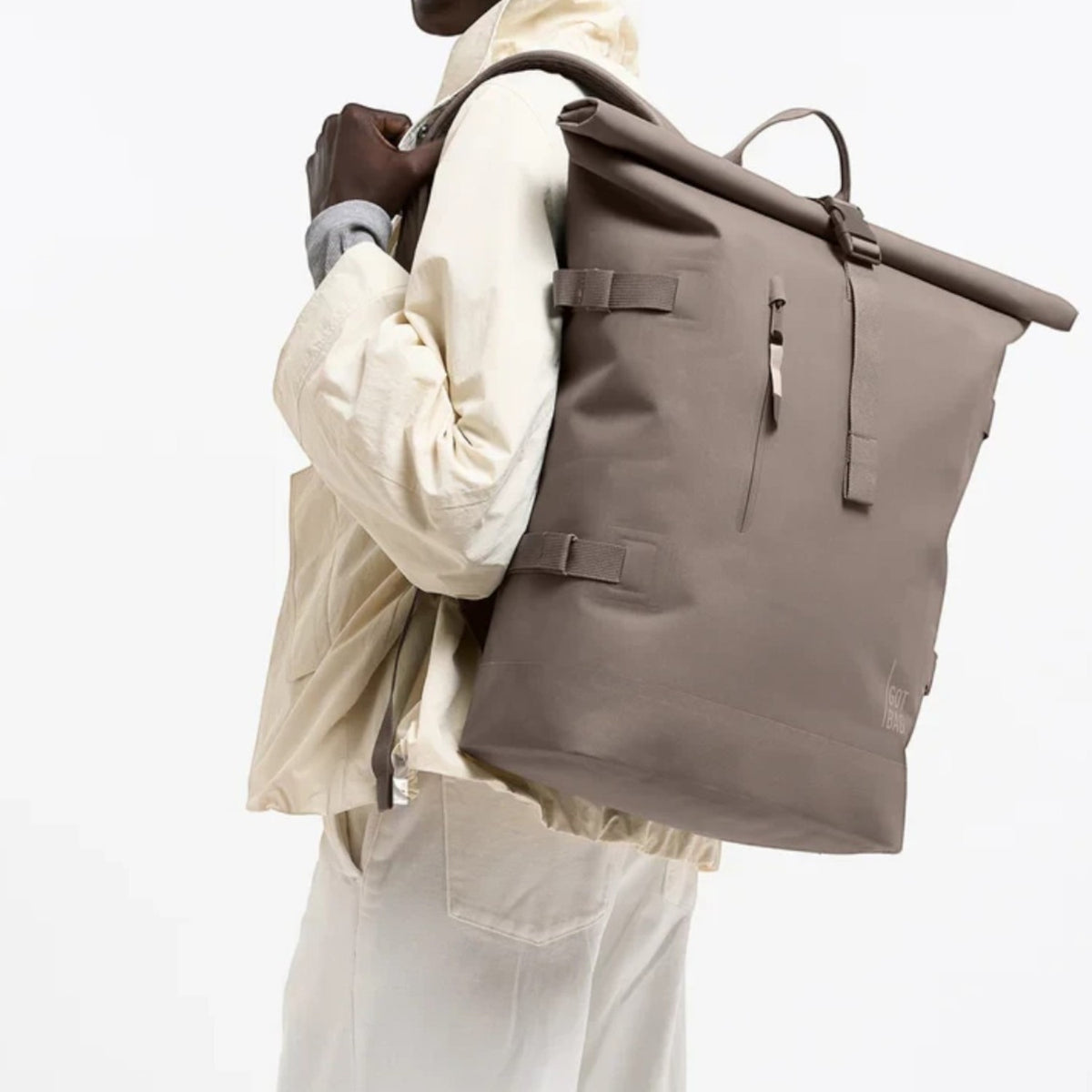 Lieblingstasche GOT BAG Rolltop 2.0 backpack in taupe worn by a smiling model against a white background