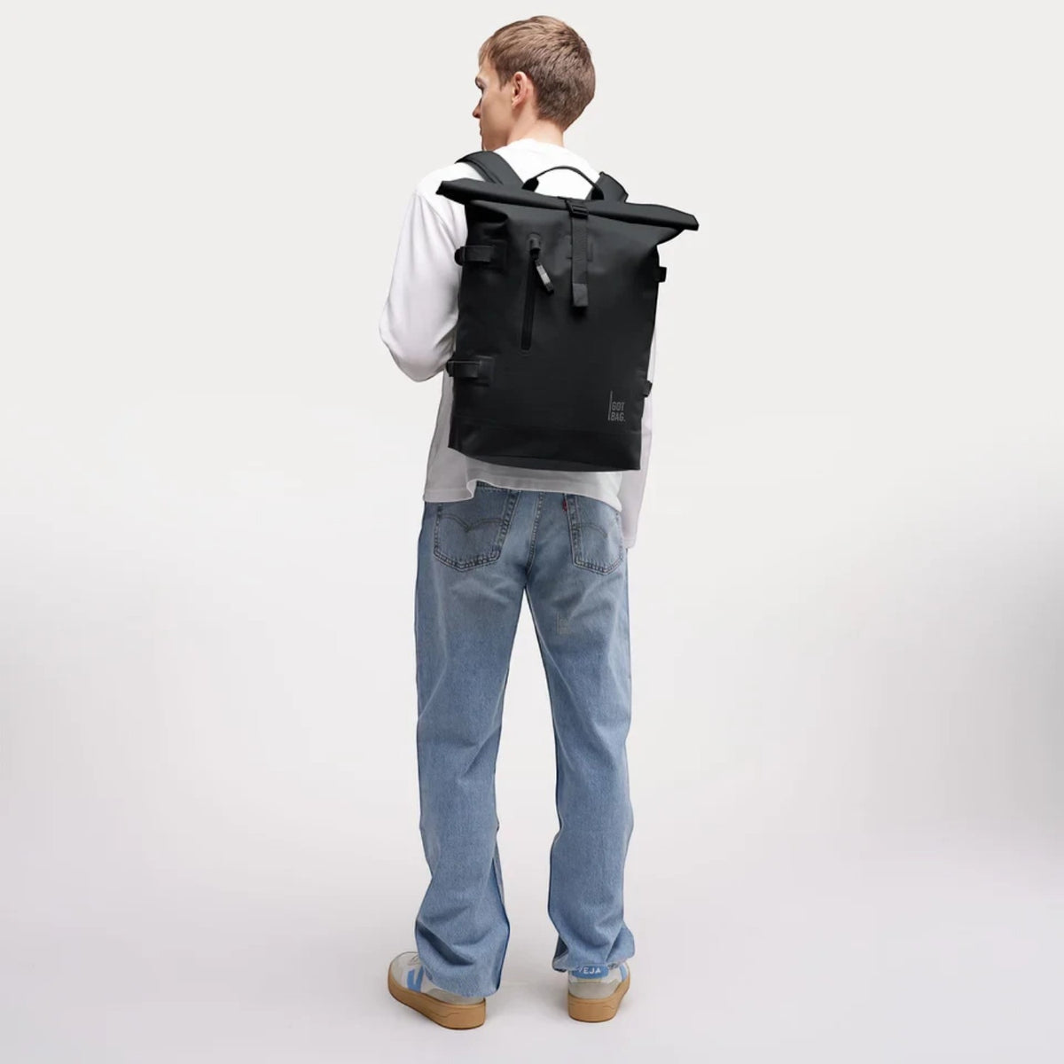 Lieblingstasche GOT BAG Rolltop 2.0 backpack in black worn by a man in a white long-sleeve shirt and blue jeans
