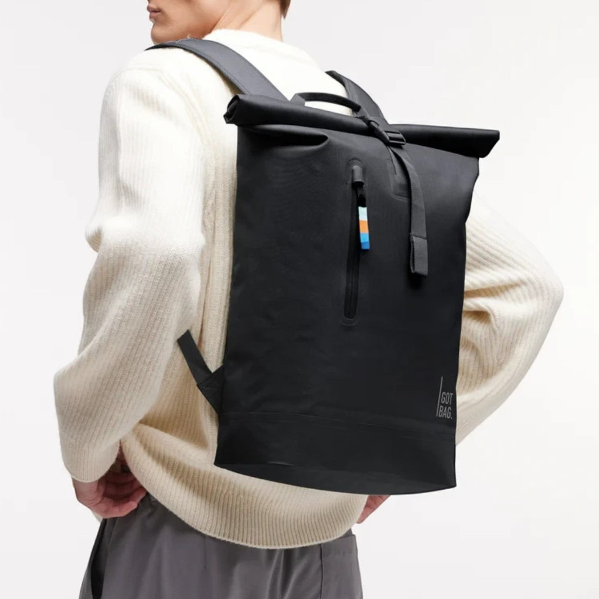 Lieblingstasche GOT BAG Rolltop Lite 2.0 black waterproof backpack worn by a man in a white sweater