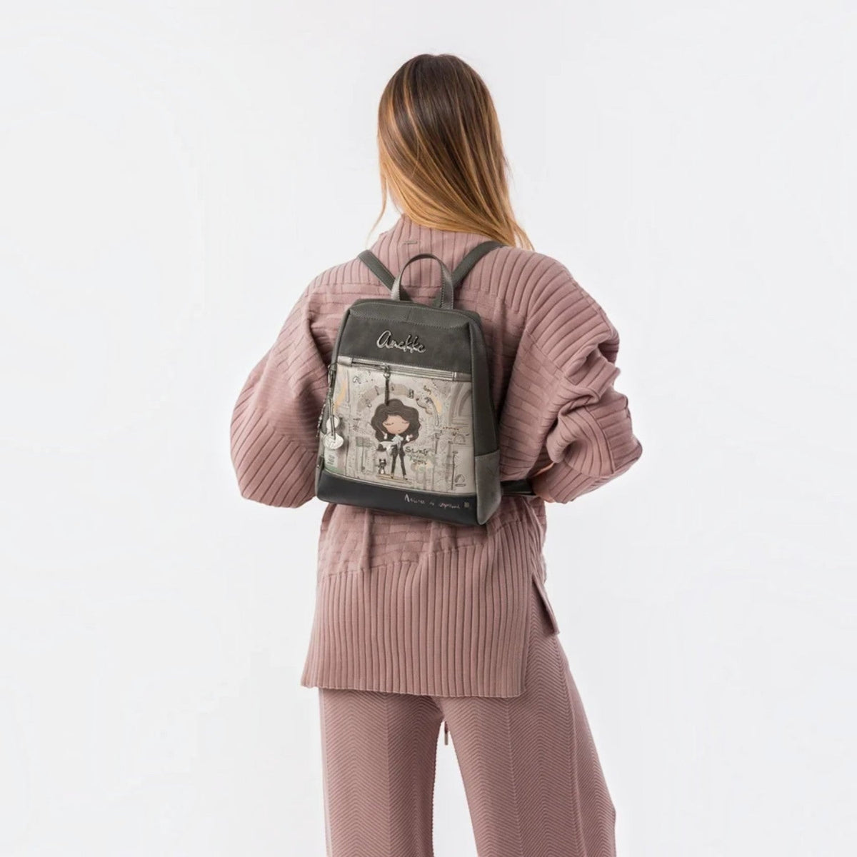 Lieblingstasche grey backpack with Anekke illustration, front zip pocket, and metallic charm on a woman's back