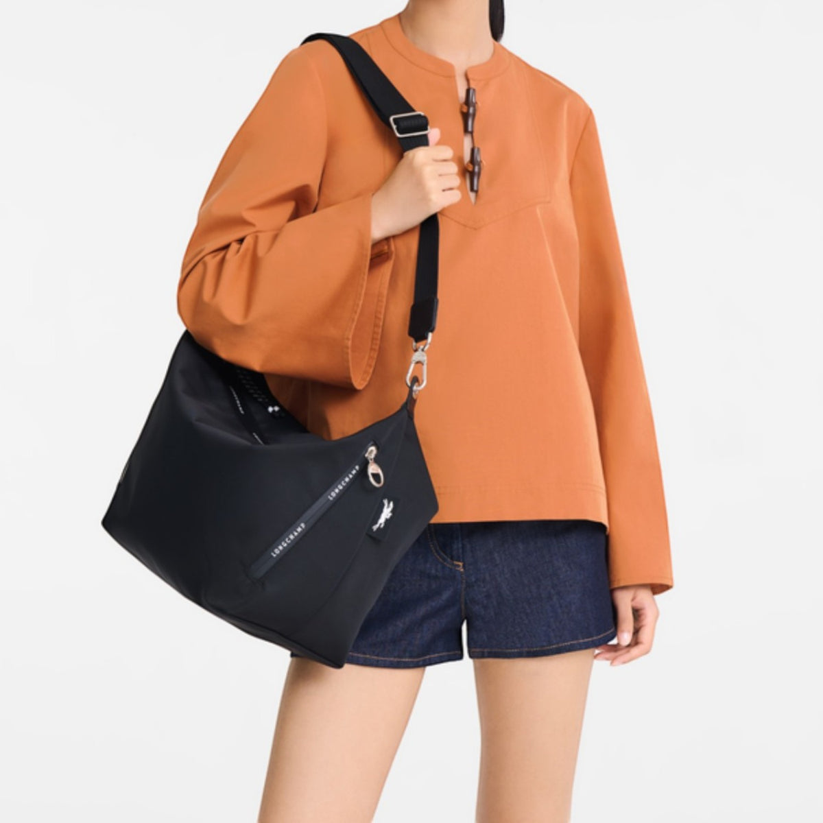Model wearing a black Lieblingstasche Le Pliage Energy medium crossbody bag with an adjustable strap