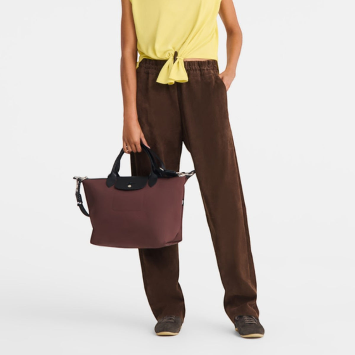 Lieblingstasche Le Pliage Energy medium handbag in burgundy recycled nylon with black rope detail held by a model