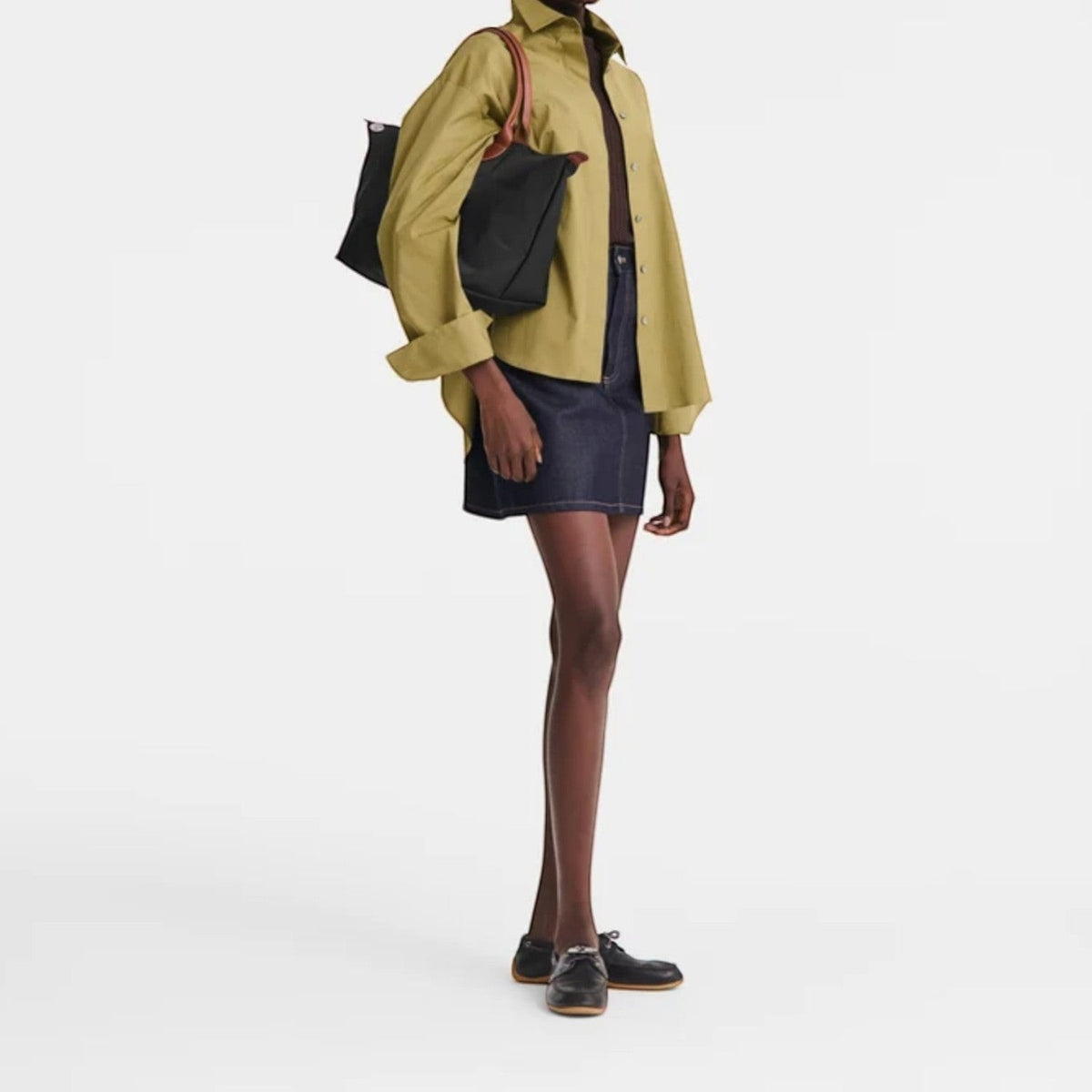 Lieblingstasche Le Pliage L black nylon tote bag with brown leather straps worn by a model.