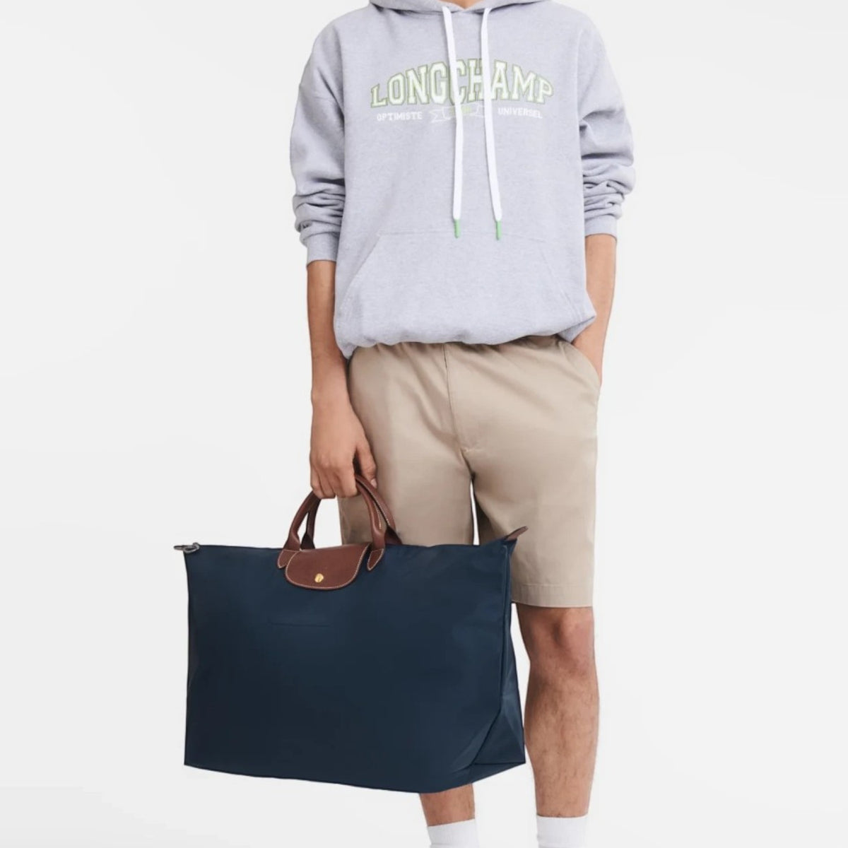 Lieblingstasche model holding a navy blue Longchamp Le Pliage XL travel bag with brown leather handles