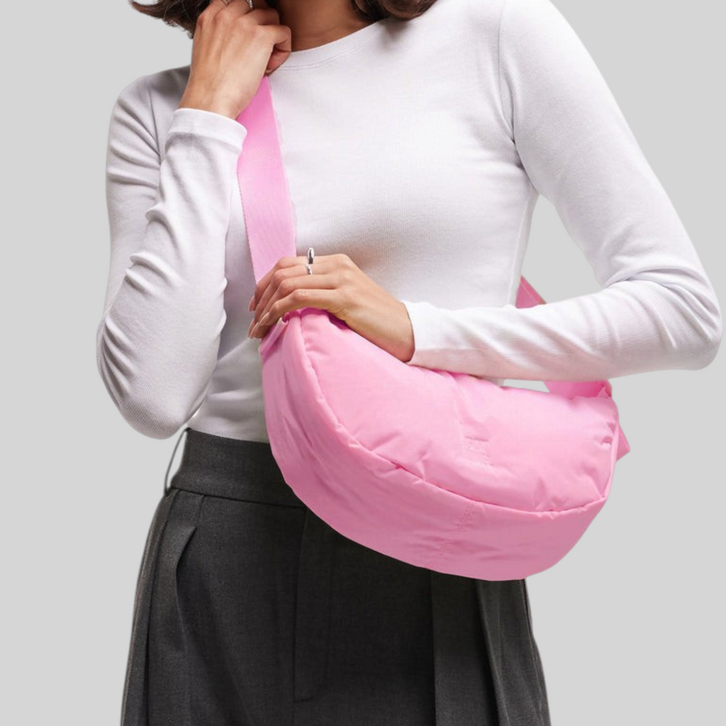 Lieblingstasche Cloud Moon Bag Small in bright pink worn as a crossbody bag by a smiling woman in a white top