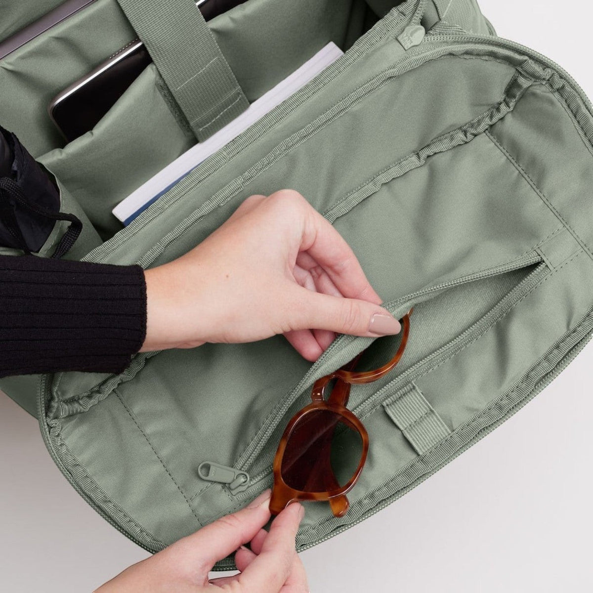 Lieblingstasche Pro Pack sage green backpack interior with organized compartments, laptop sleeve, and sunglasses.