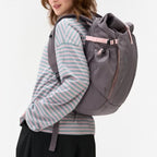 Lieblingstasche Roll Pack 2.0 in grey with pink accents, worn by a woman, featuring a rolltop and side pockets.