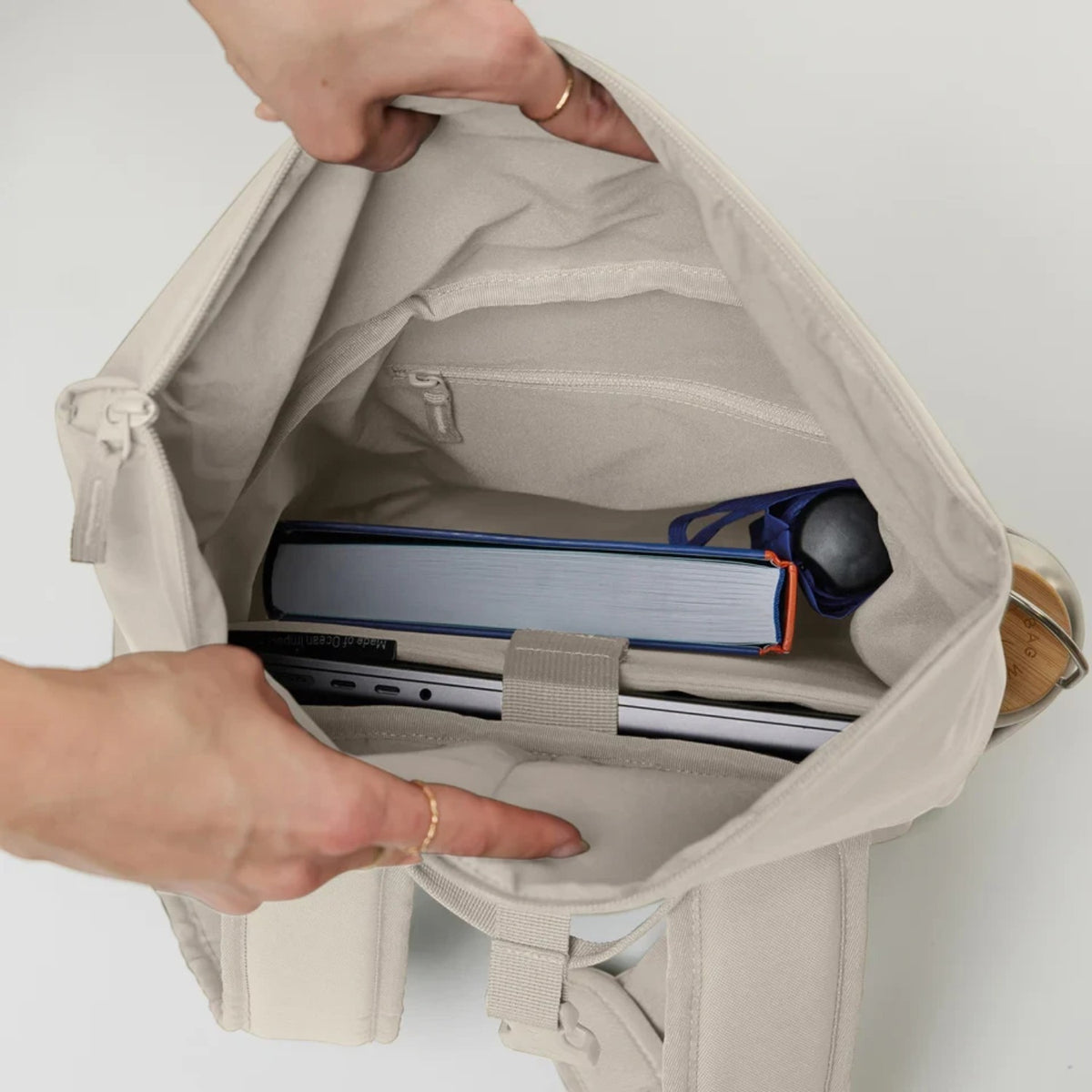 Lieblingstasche Rolltop Easy Small backpack interior view showing laptop compartment, book, and water bottle storage.