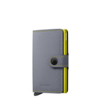 Lieblingstasche Secrid Miniwallet Matte in grey leather with a lime green card protector and snap button closure.